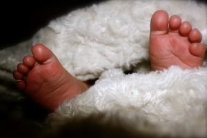 白い服を着た赤ちゃんの足